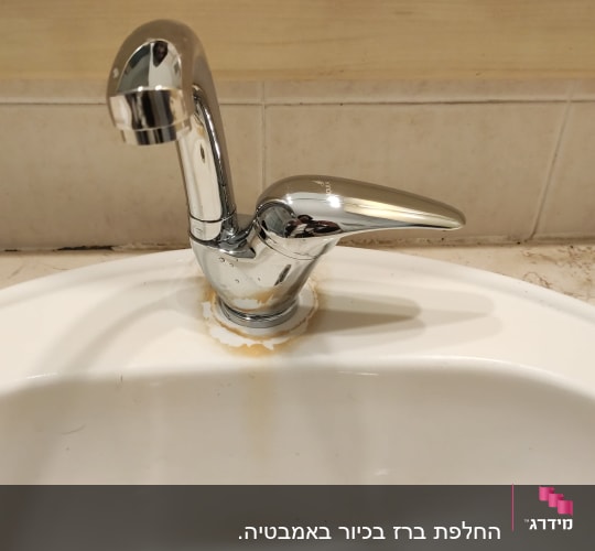 ברז כרום עם כתמי חלודה בכיור לבן